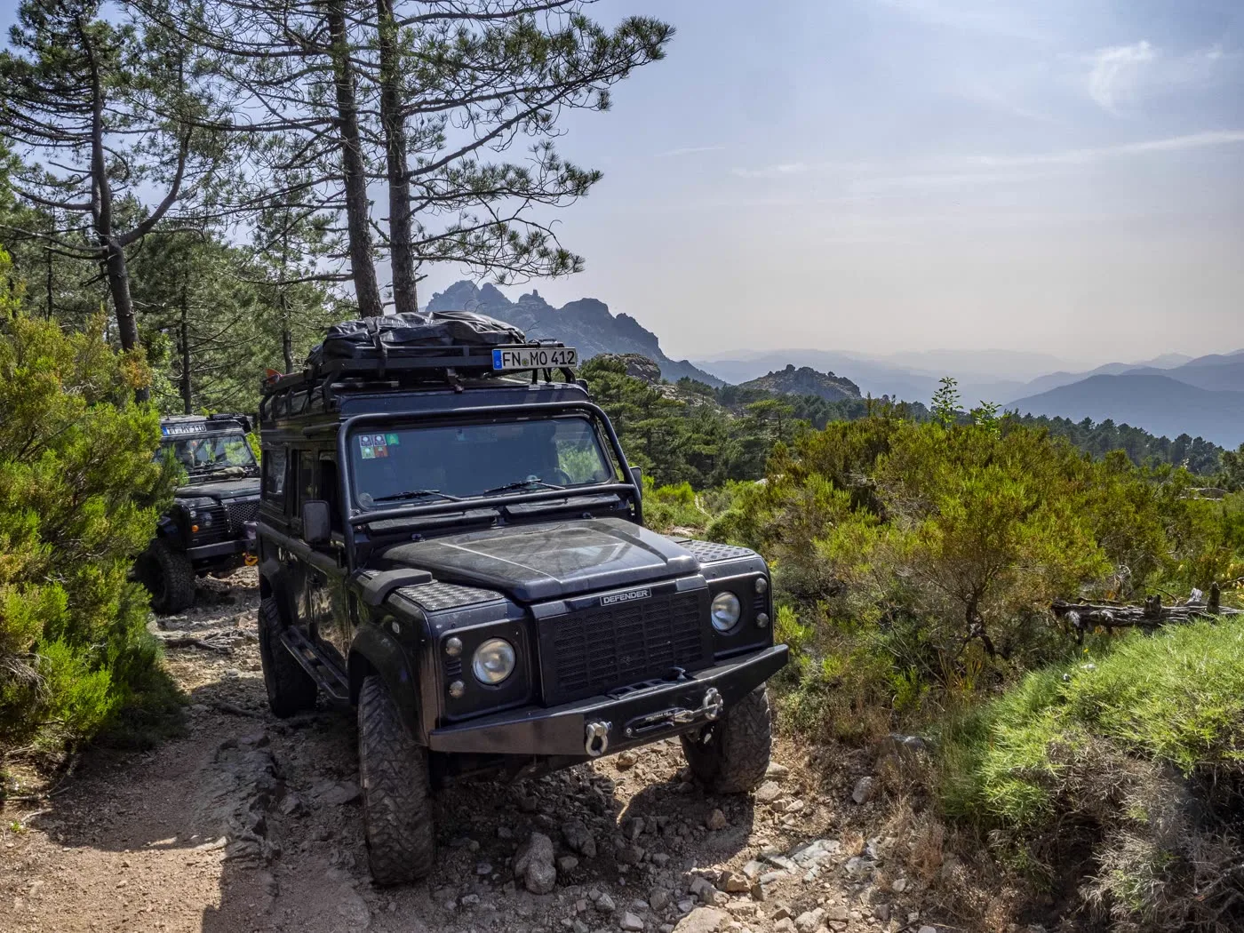 Defender auf einem Bergpfad mit Blick über die Berge
